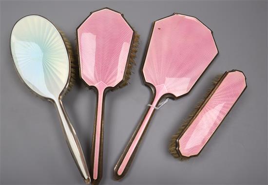 A George VI silver and pink guilloche enamel three piece mirror and brush set, Birmingham, 1947 and one other silver & enamel brush.